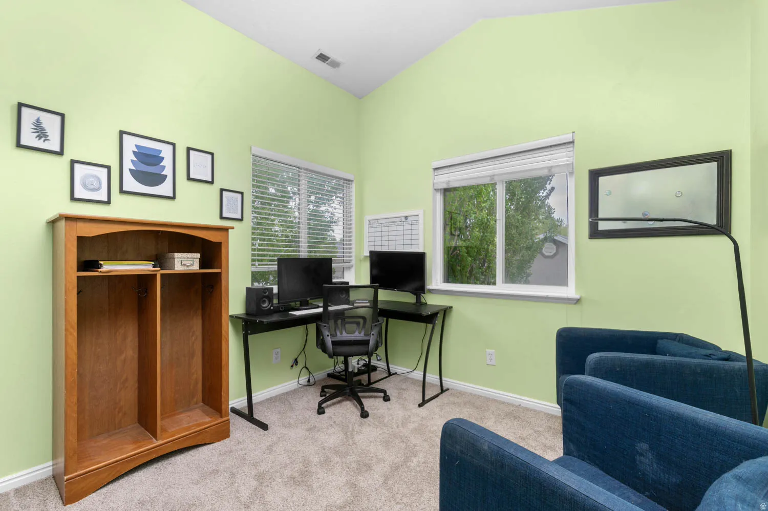 Office with light carpet and vaulted ceiling