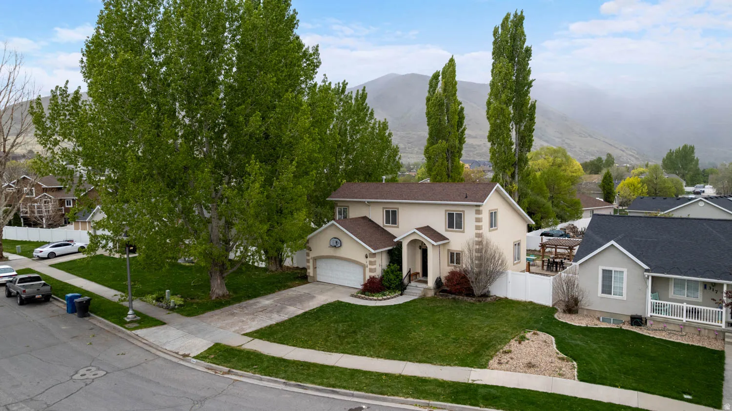 Traditional home featuring driveway, stucco siding, an attached garage, and a mountain view