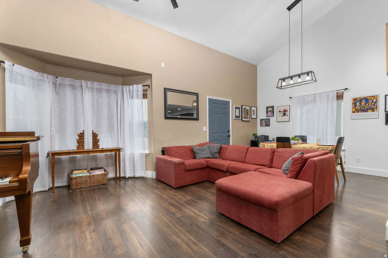 Living area with lofted ceiling and dark wood-style floors