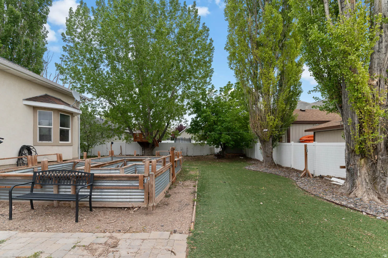 Fenced backyard featuring a garden