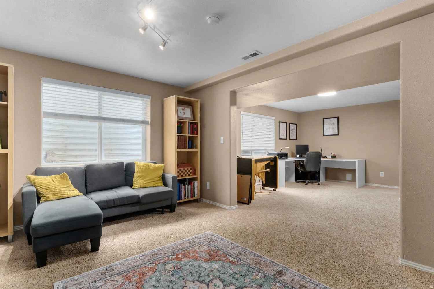 Office space with light colored carpet and baseboards