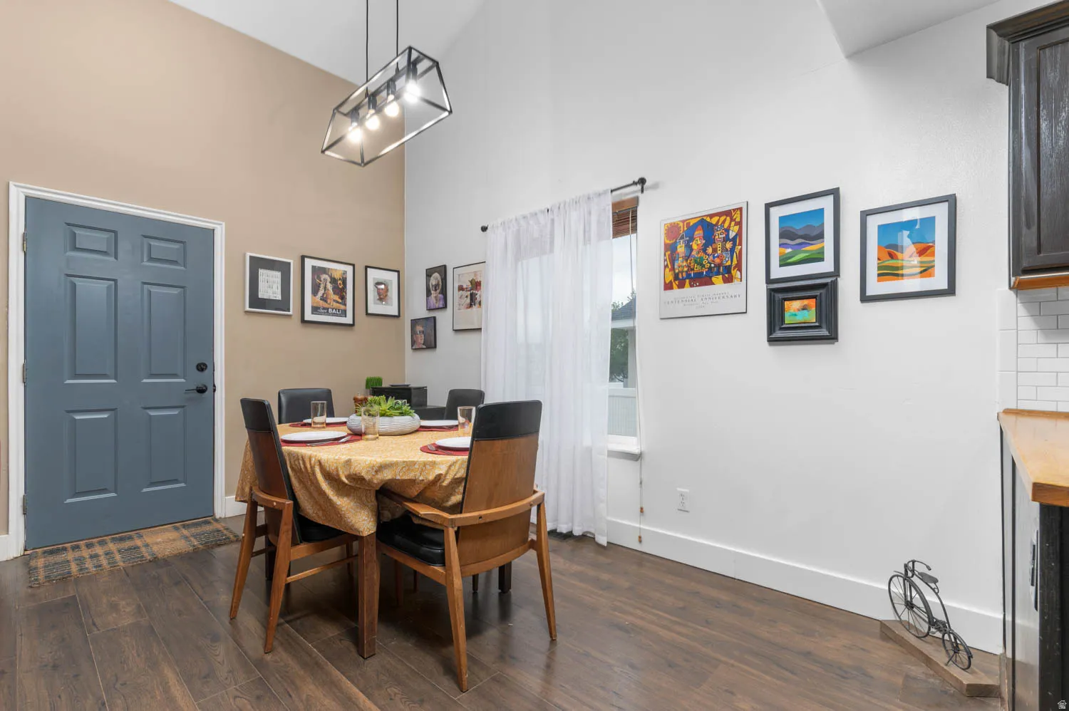 Dining room with dark wood-type flooring and a high ceiling