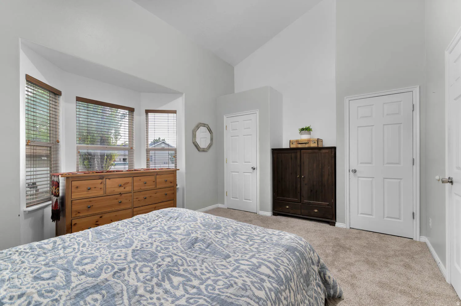 Bedroom featuring vaulted ceiling and light colored carpet