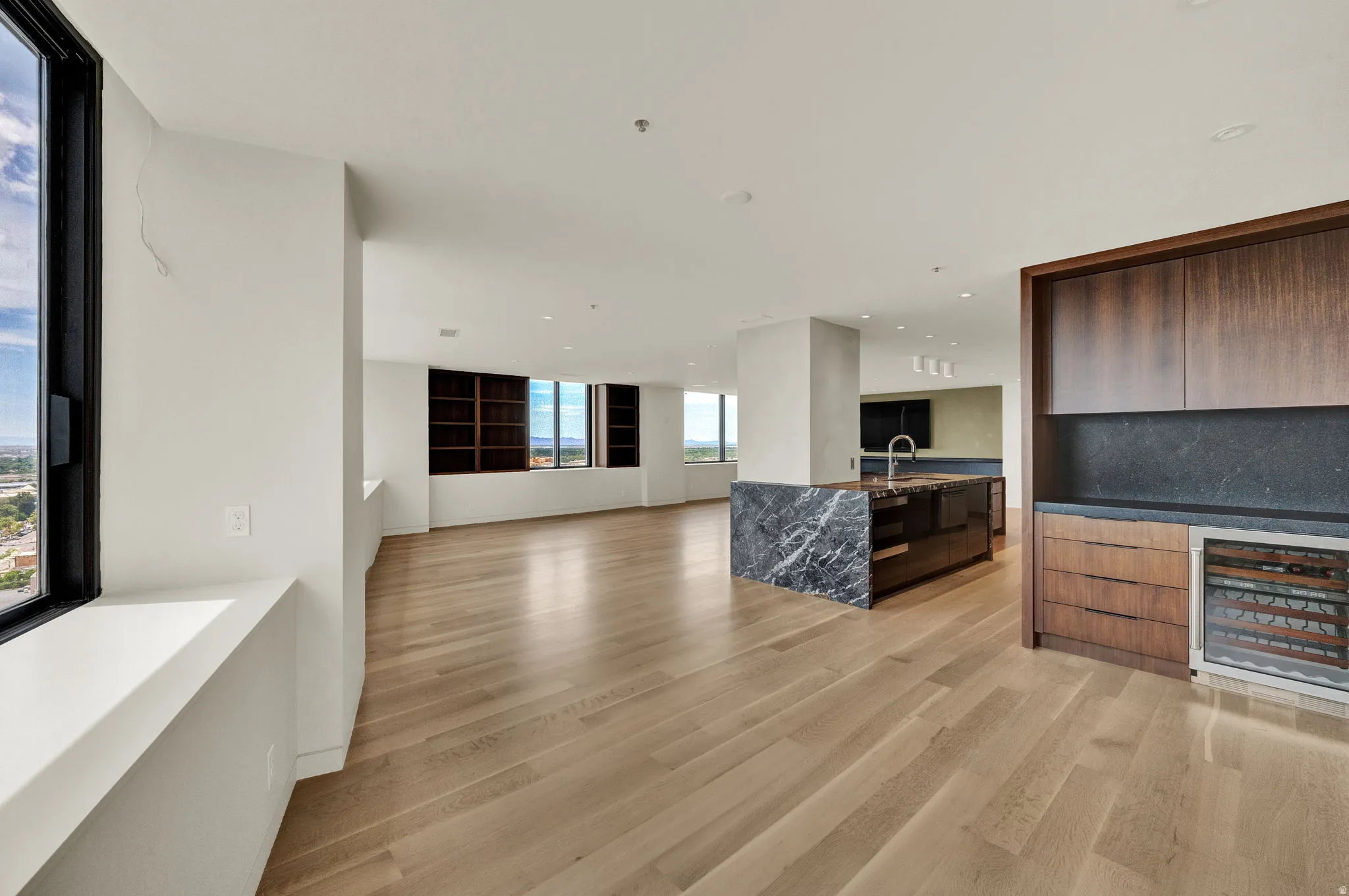 Unfurnished living room featuring wine cooler and light wood-style flooring