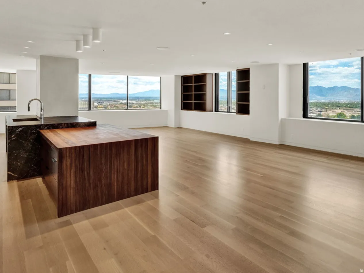 Kitchen featuring open floor plan, a mountain view, an island with sink, modern cabinets, and light wood-type flooring