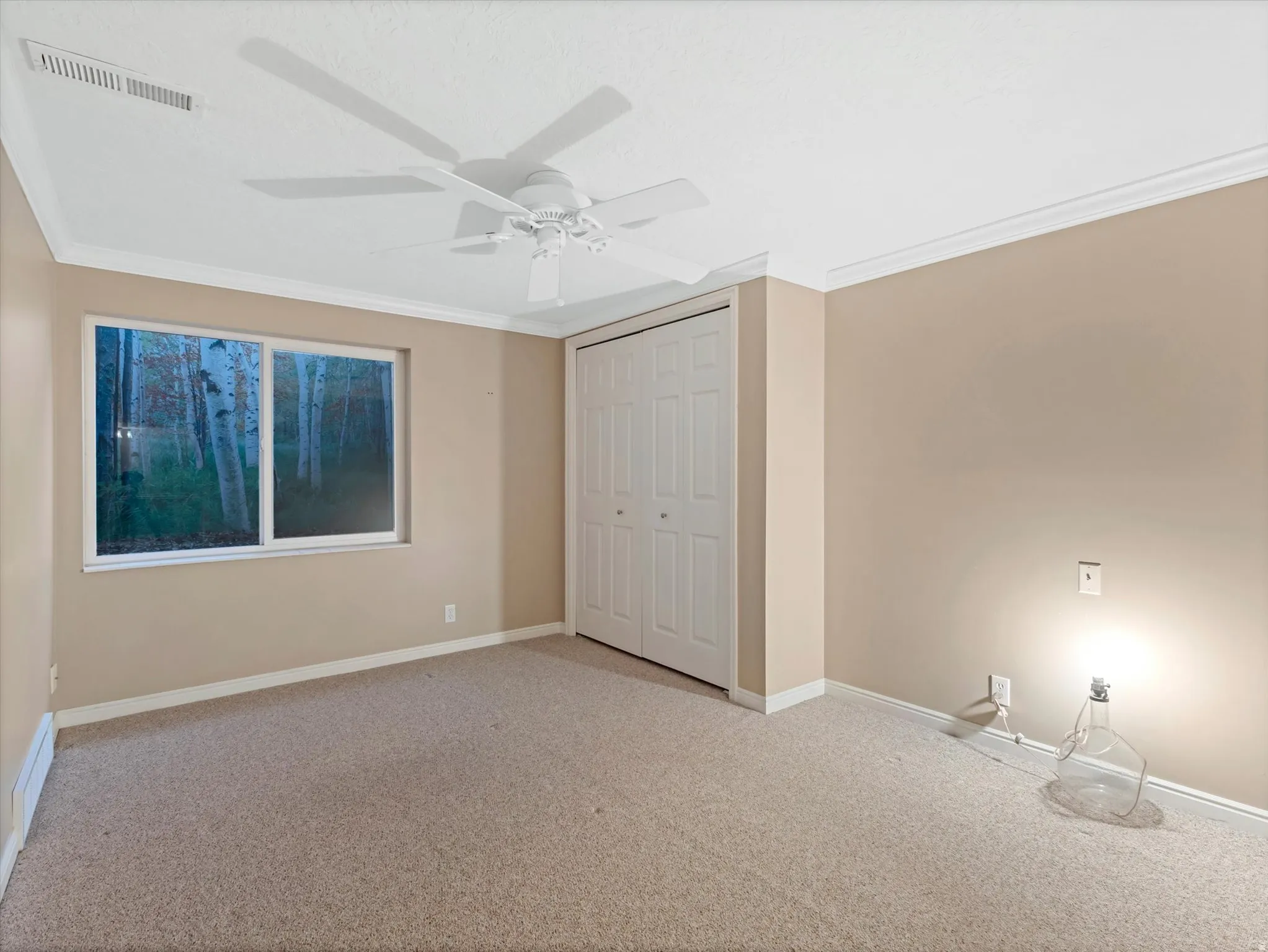 Bedroom with crown molding, a double closet, and ceiling fan
