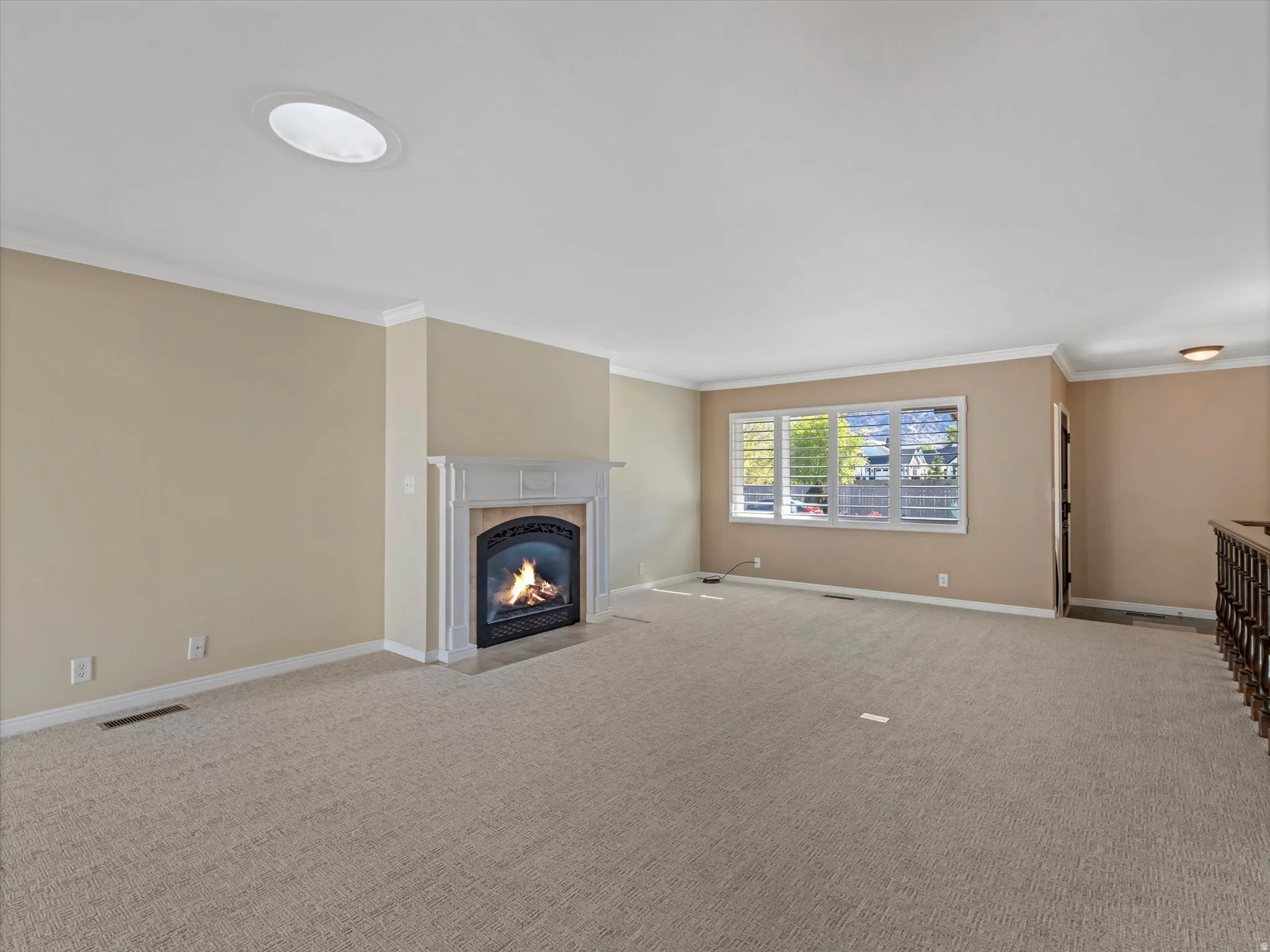 Great room with gas fireplace, crown molding, fresh new carpeting