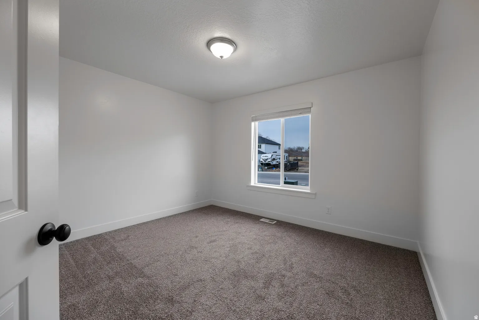Empty room with carpet and baseboards