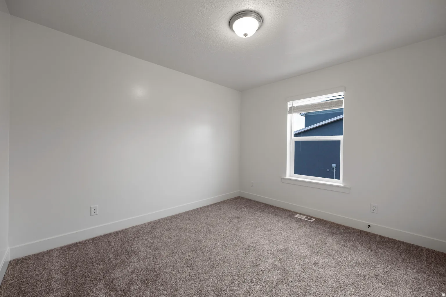 Spare room with carpet floors and a textured ceiling