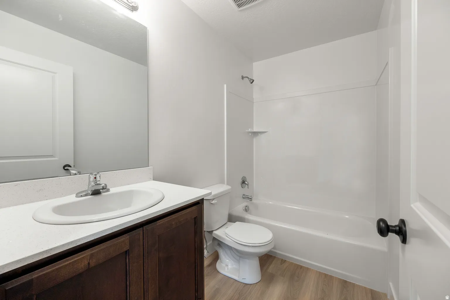 Bathroom featuring vanity, light wood-style flooring, and bathtub / shower combination