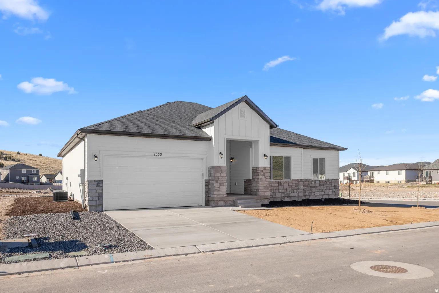 View of front of property featuring roof with shingles, a garage, driveway, stone siding, and a residential view