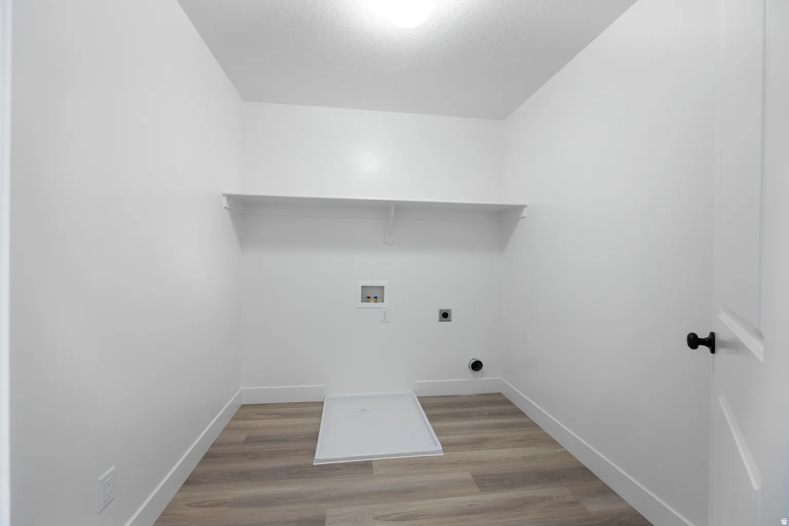 Laundry room with light wood-style floors, hookup for a washing machine, and electric dryer hookup