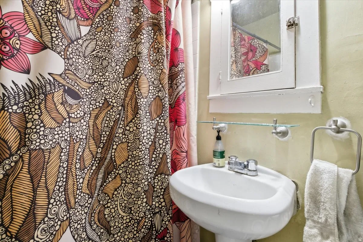 Bathroom with a sink and curtained shower