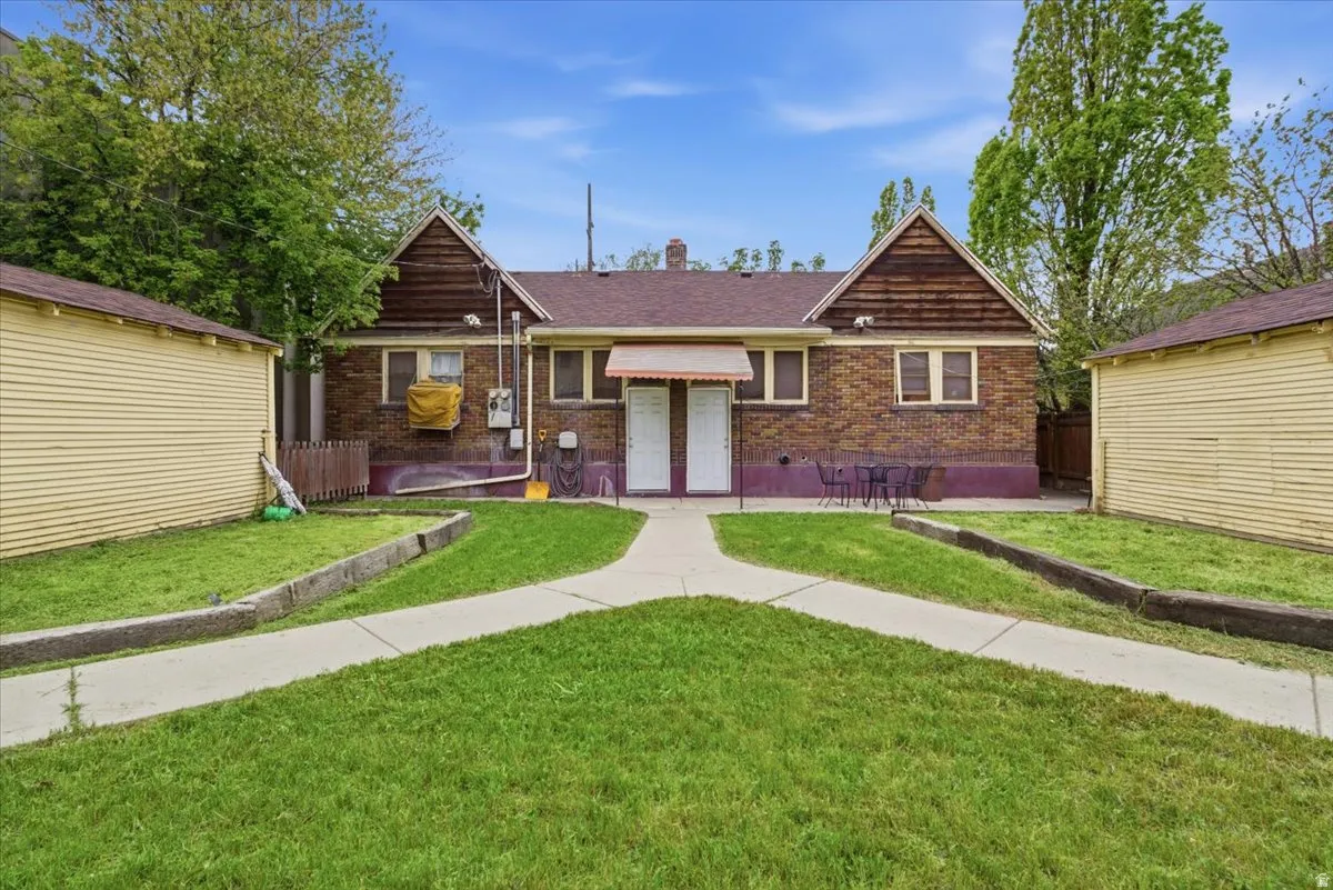 View of front of house with a chimney and brick siding