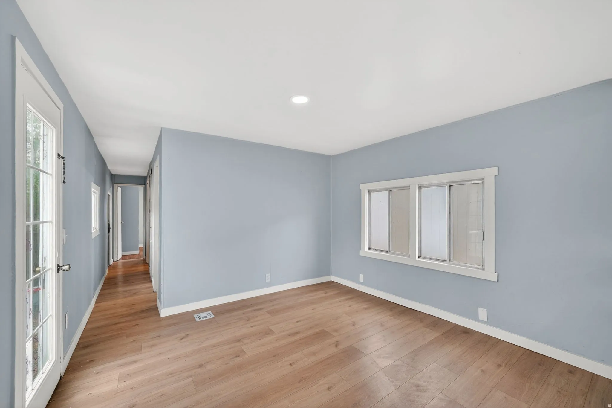 Spare room featuring light wood-style flooring, healthy amount of natural light, and recessed lighting