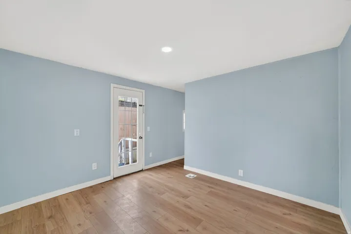 Empty room with light wood-style floors and recessed lighting