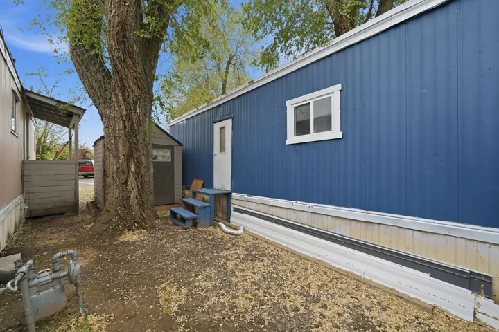 View of side of home with a shed