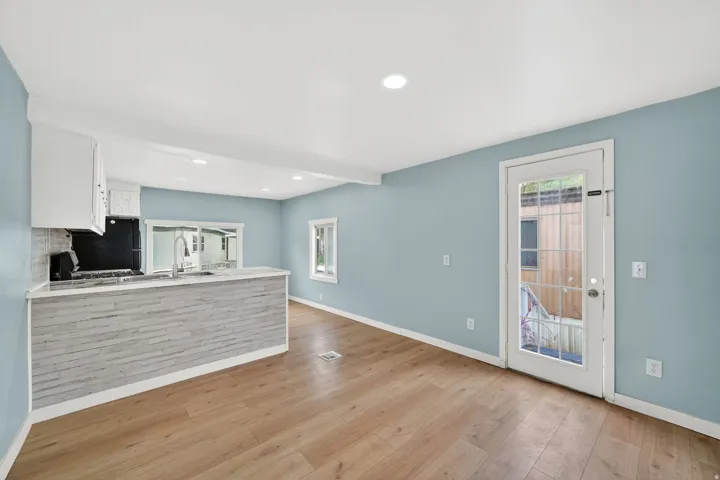 Kitchen featuring white cabinetry, a peninsula, light wood-type flooring, recessed lighting, and stainless steel range with gas stovetop
