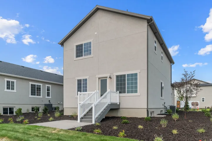 Rear exterior featuring a neutral stucco finish and a multi-level deck with white railings