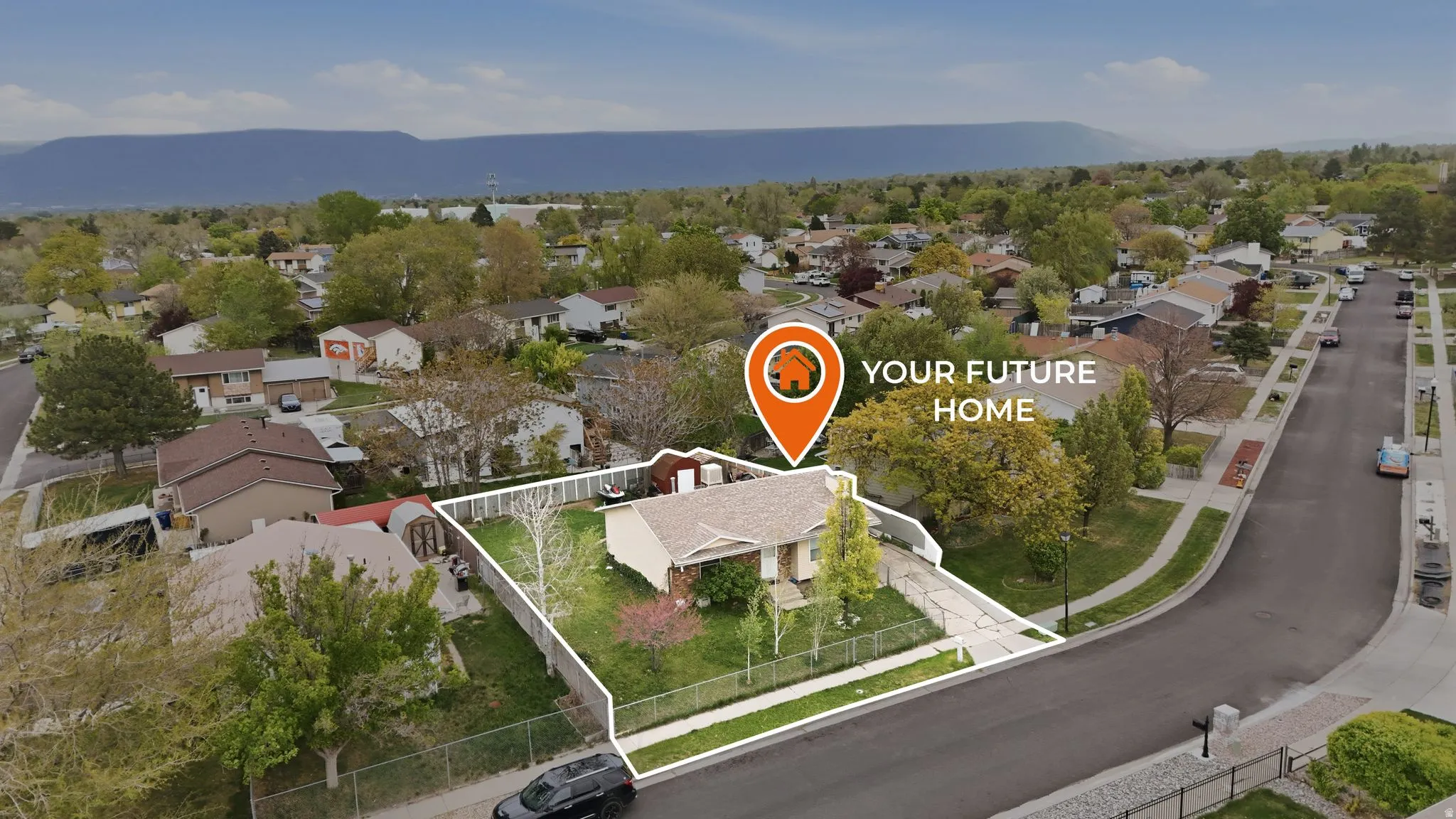Aerial view of residential area featuring a mountain backdrop and property boundaries highlighted