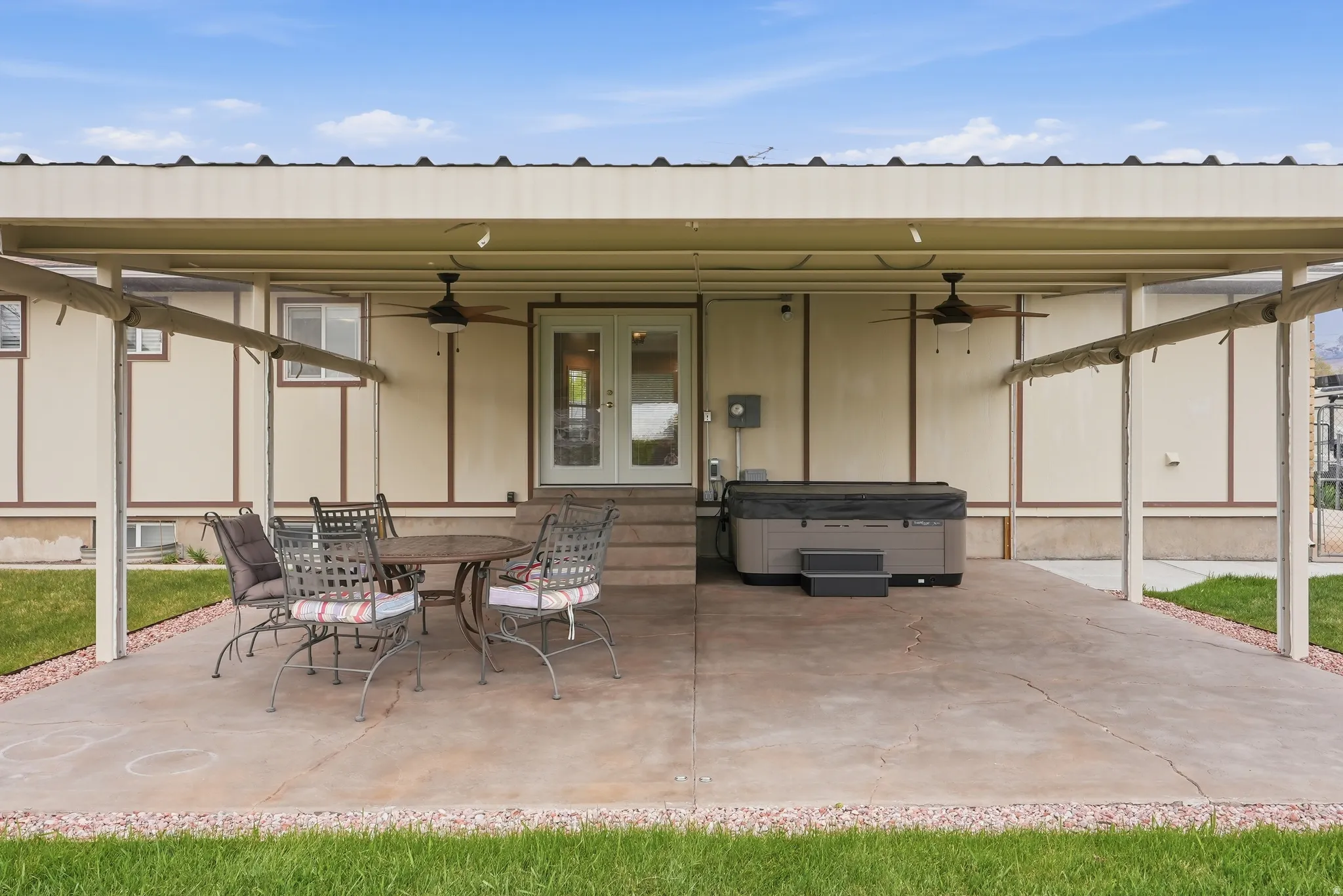View of patio with a ceiling fan, outdoor dining space, french doors, and a hot tub