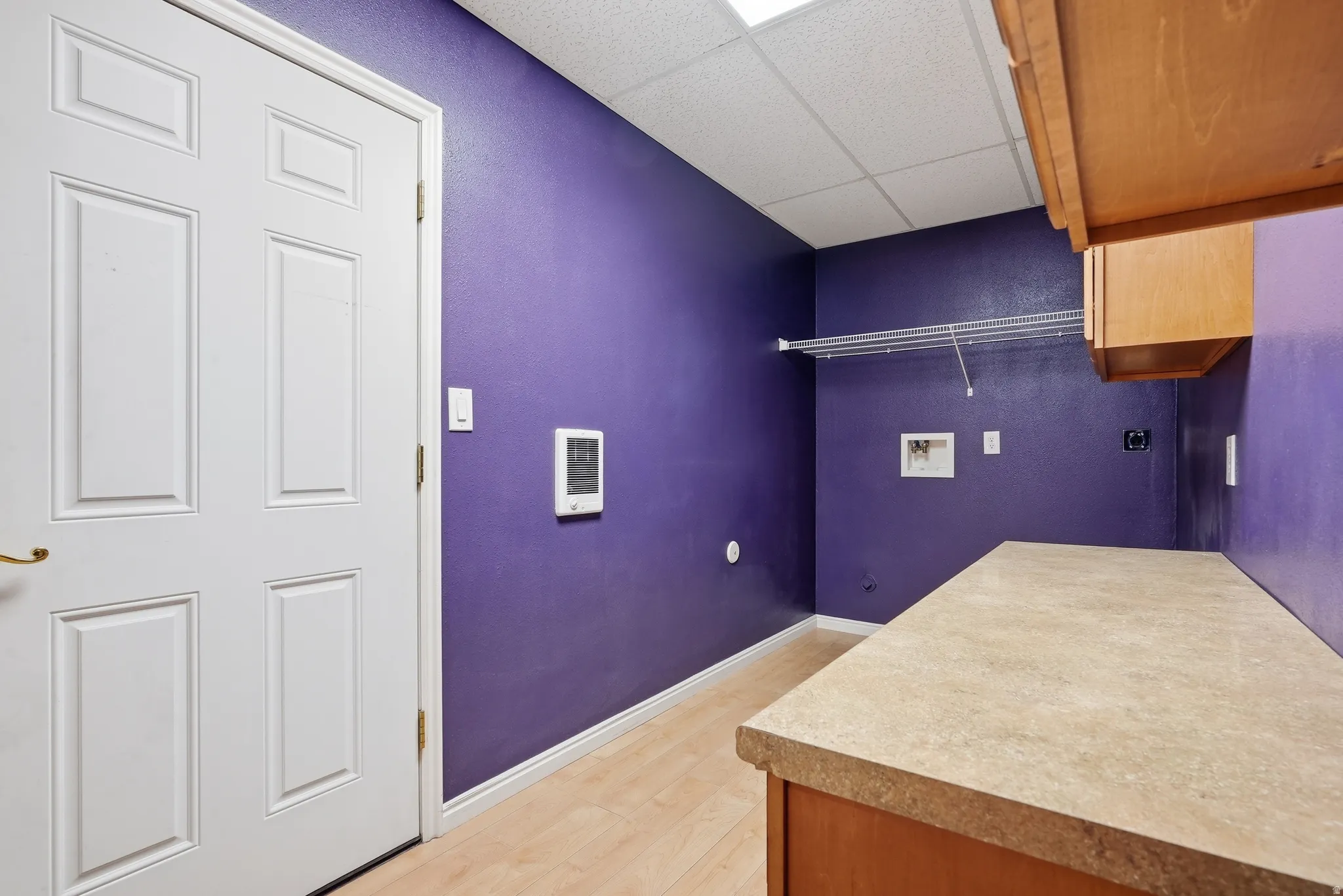 Laundry room with washer hookup, a paneled ceiling, cabinet space, light wood-type flooring, and hookup for an electric dryer