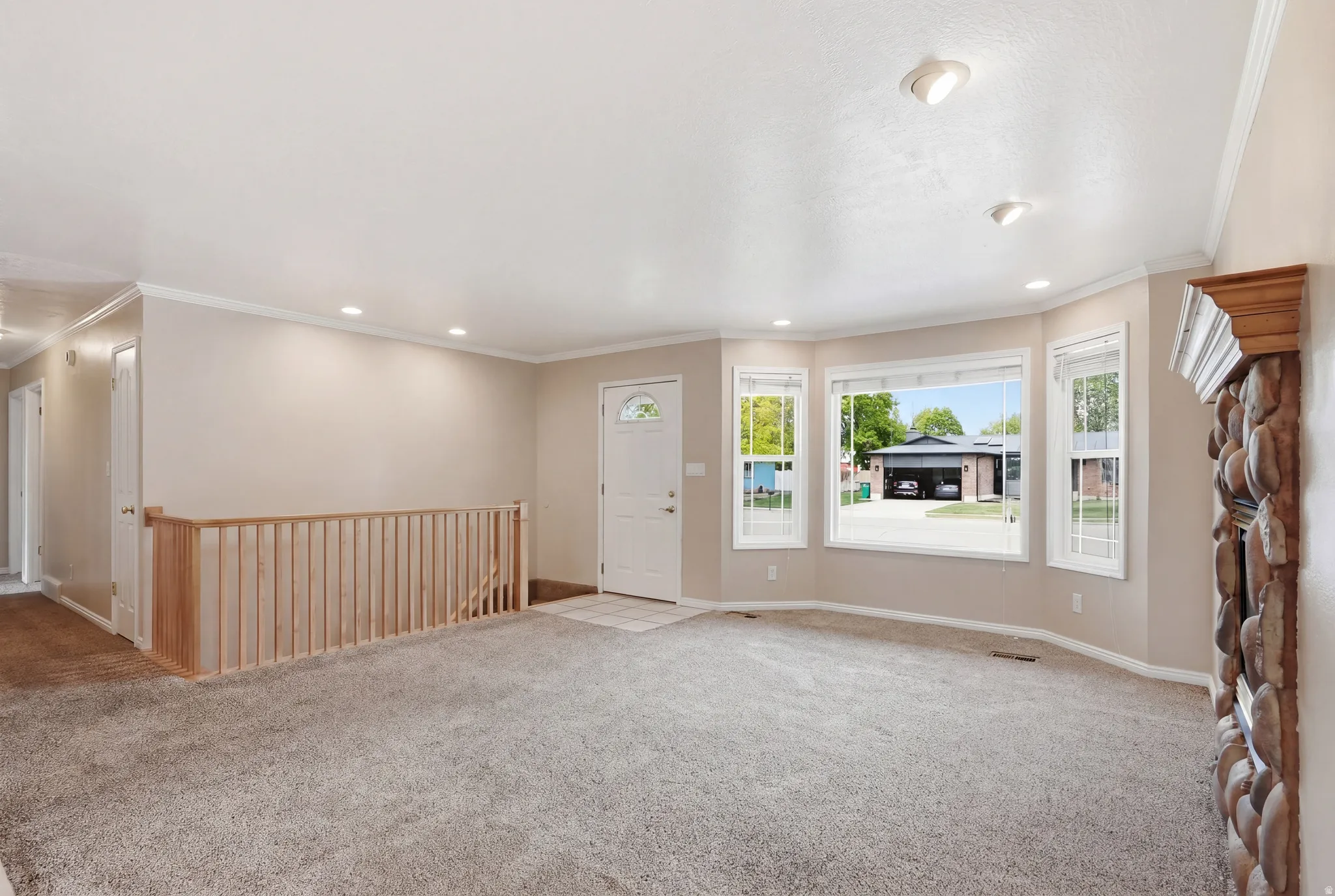 Unfurnished living room featuring carpet, crown molding, and recessed lighting