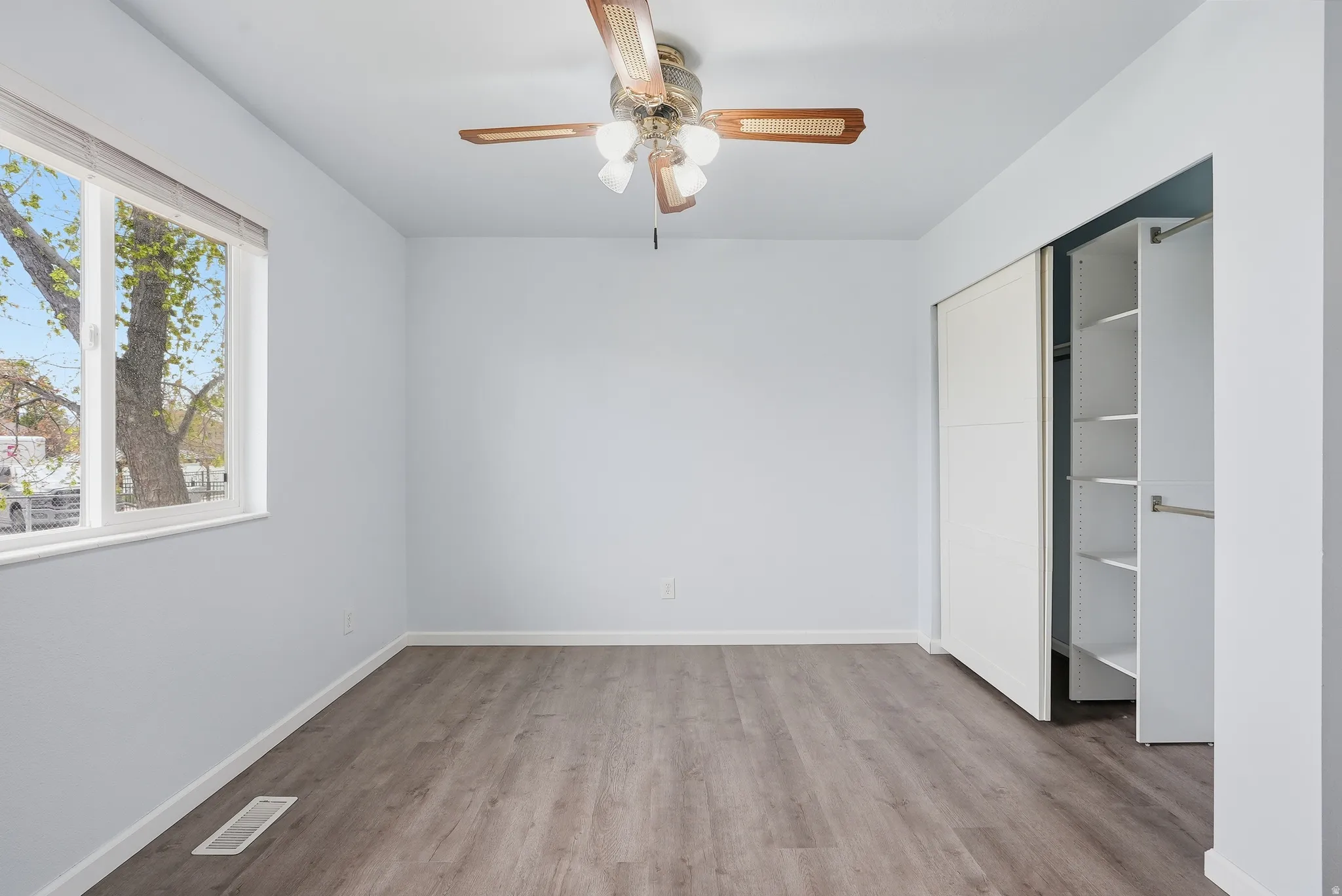Unfurnished bedroom with light wood-style floors, a ceiling fan, and a closet