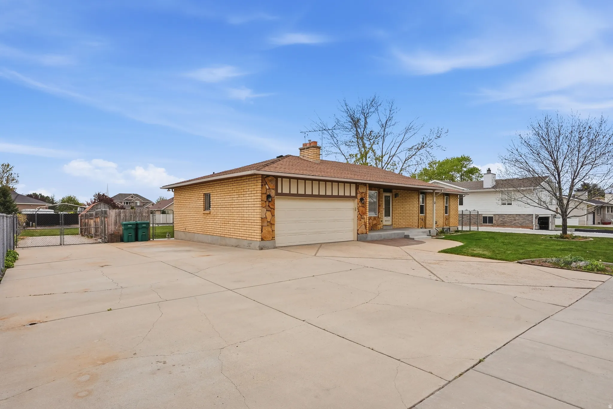 Ranch-style house with brick siding, a garage, driveway, and a chimney