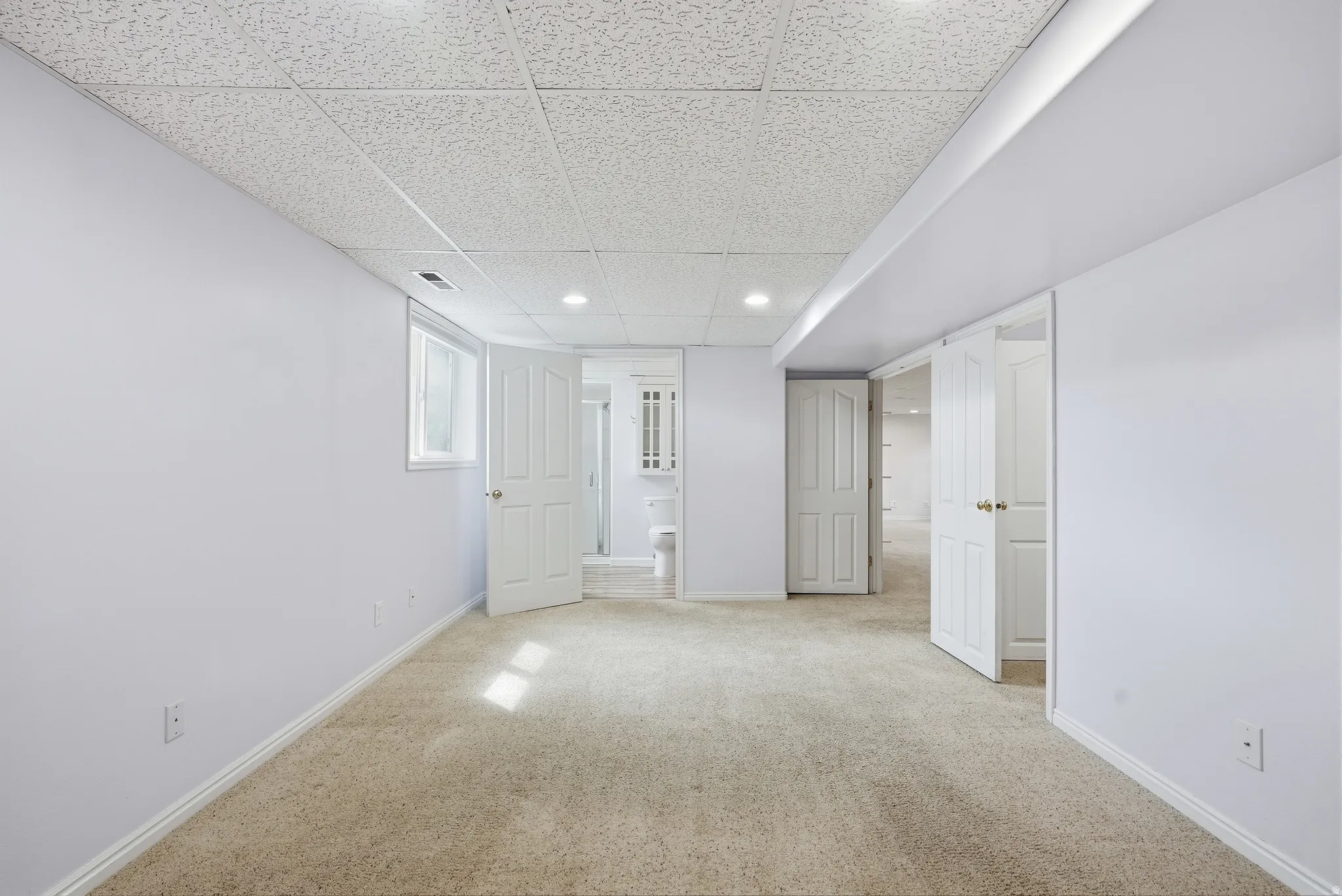 Finished basement with a drop ceiling, light carpet, and recessed lighting