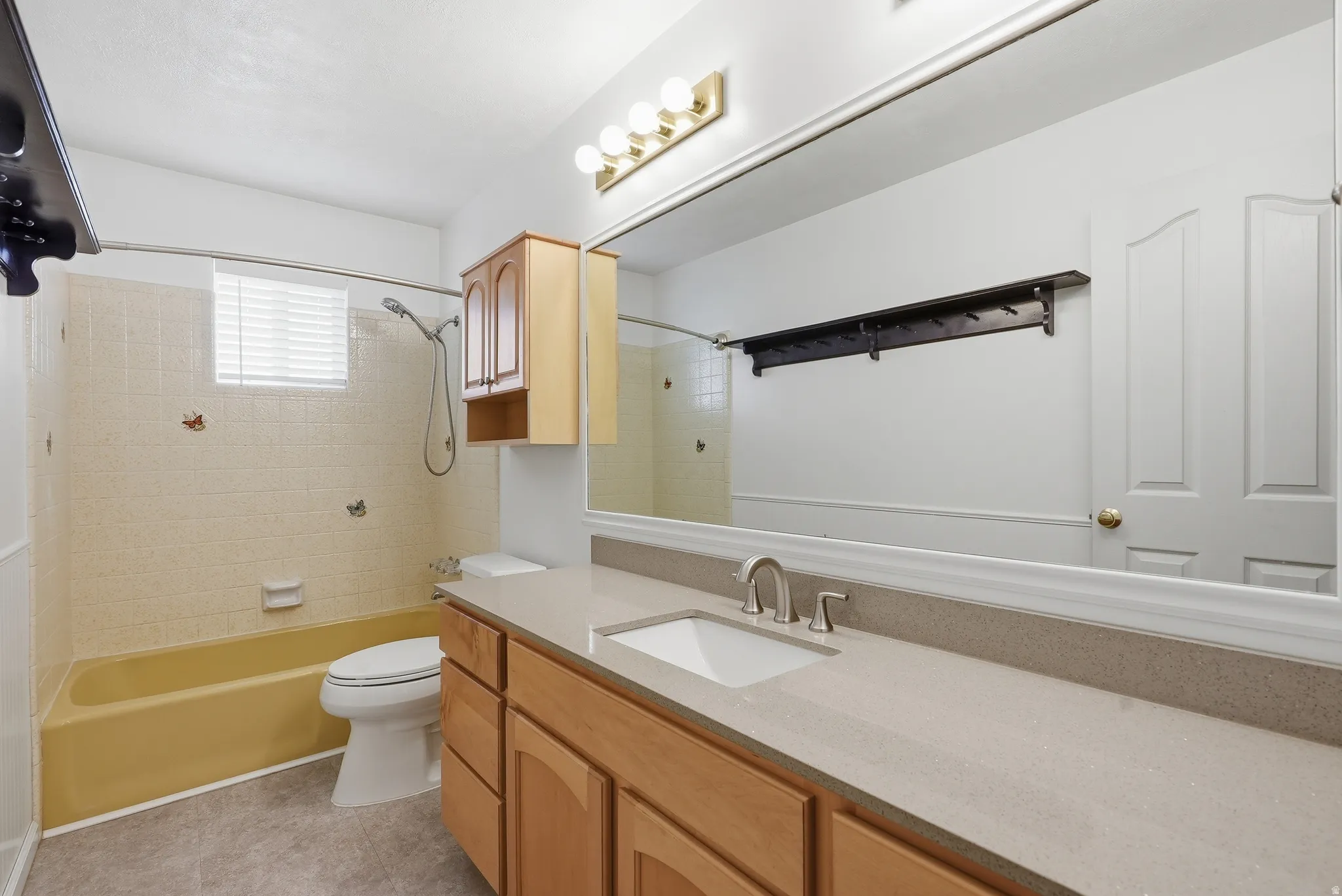 Bathroom with vanity, shower / tub combination, and light tile patterned floors