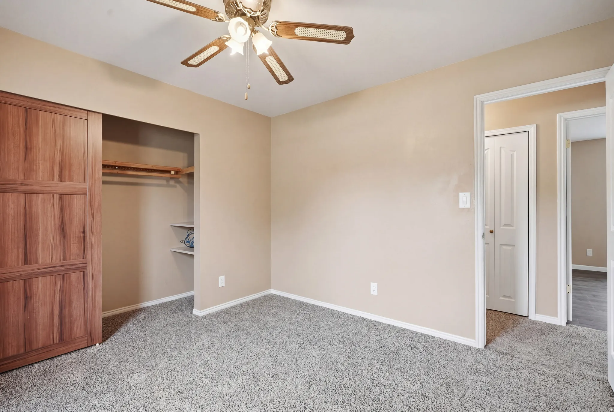 Unfurnished bedroom with a closet, a ceiling fan, and light carpet