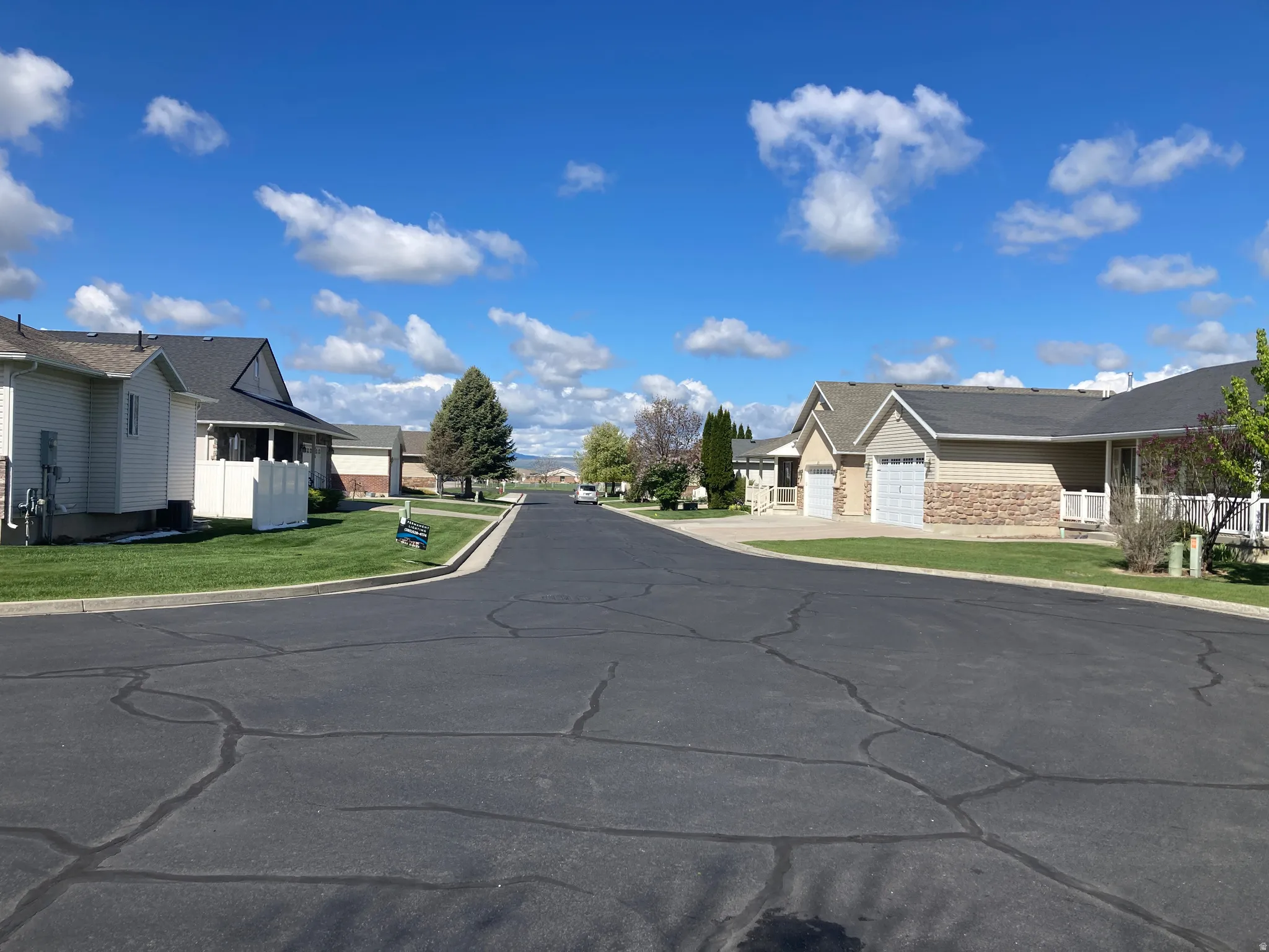 View of asphalt road featuring a residential view and curbs
