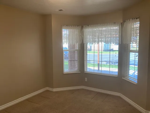 Unfurnished room with baseboards and light carpet