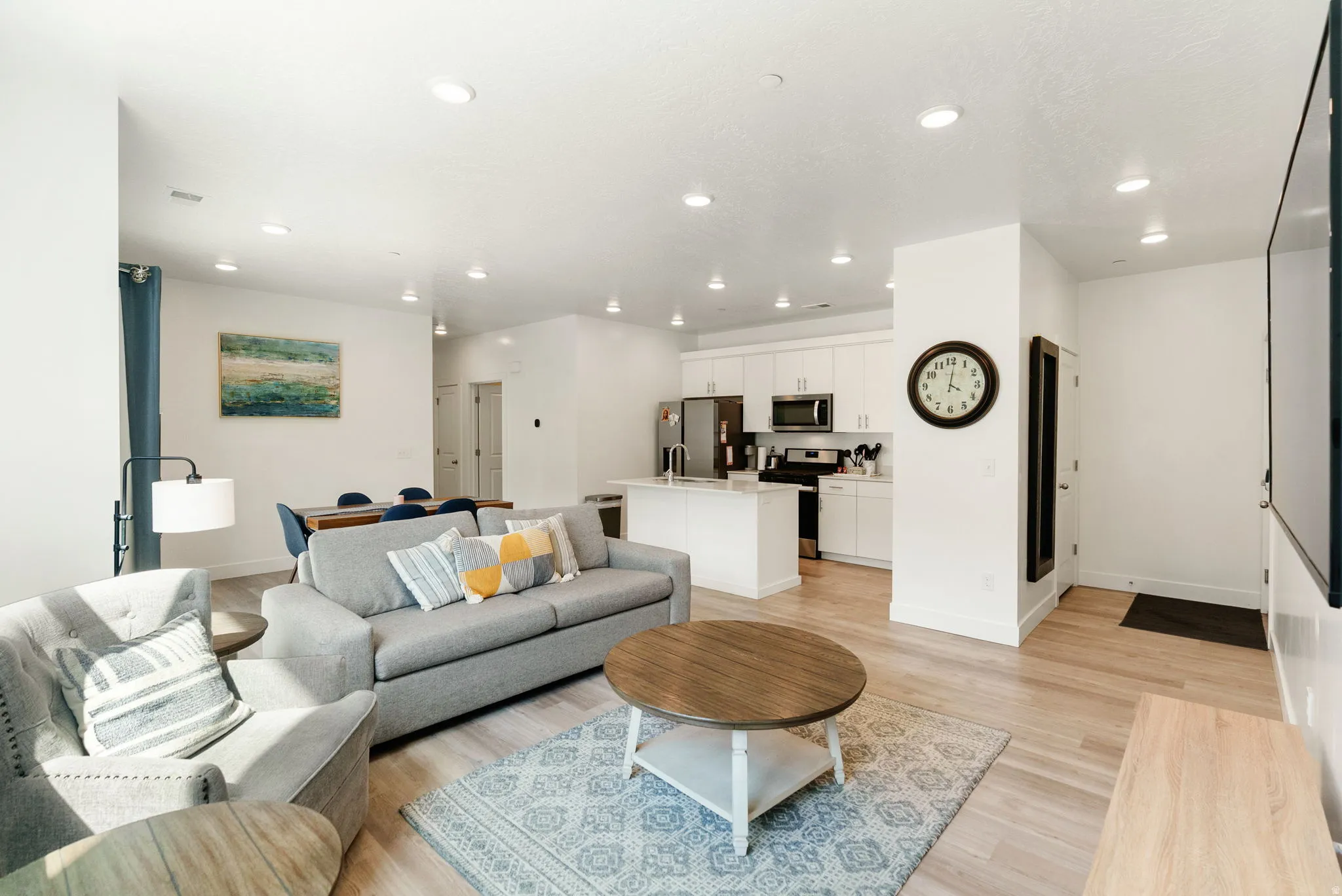 Living room with light wood finished floors and recessed lighting