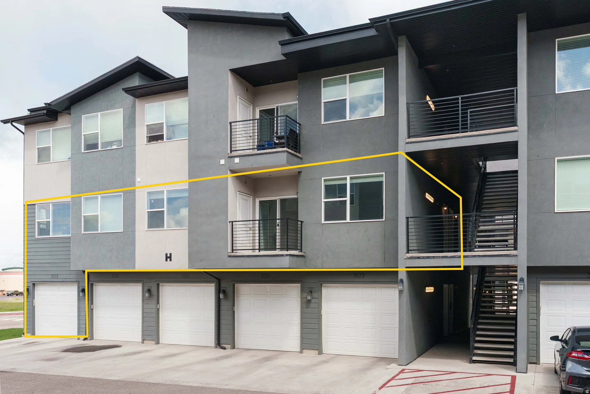 View of building exterior with a garage and driveway parking space