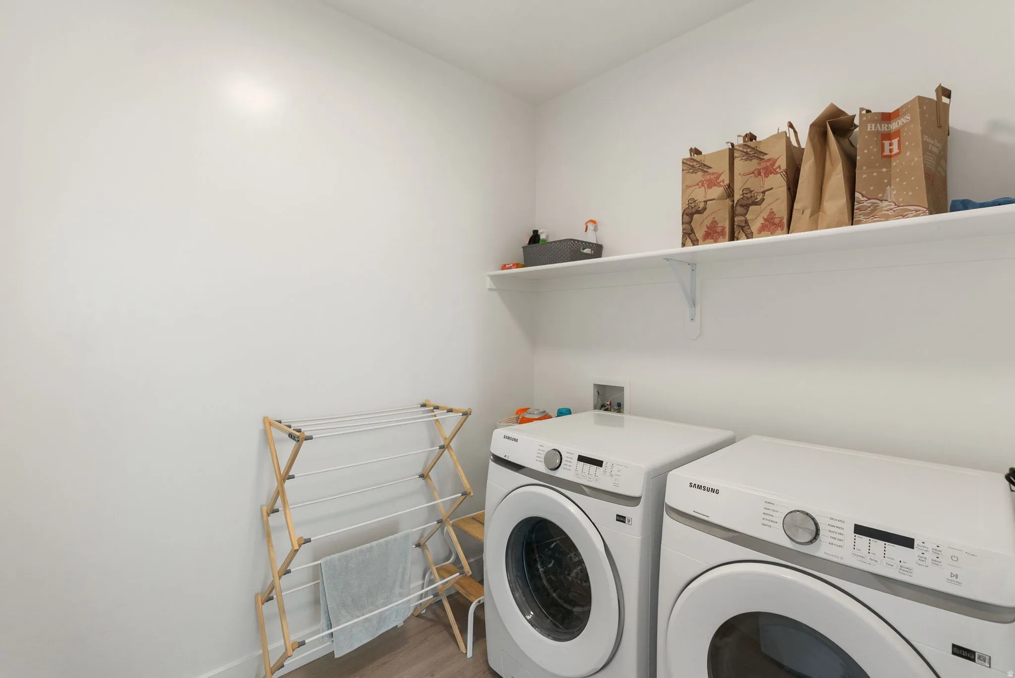 Laundry area with washing machine and dryer and light wood-style floors