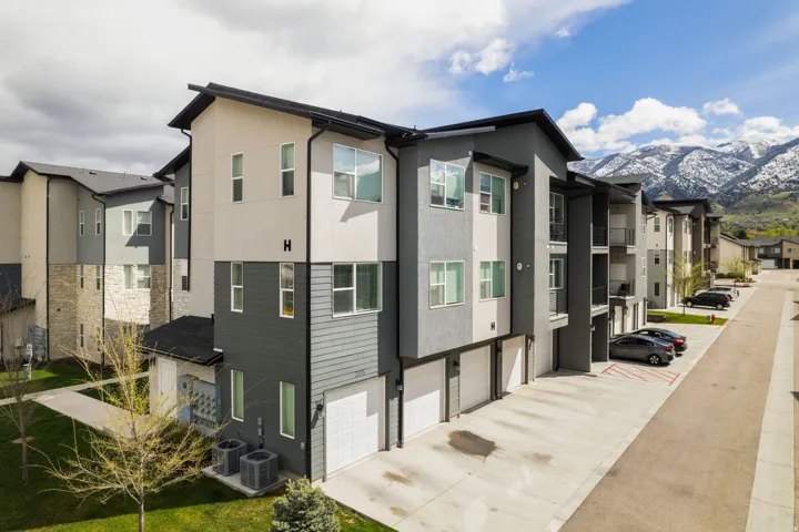 View of side of home with stucco siding, an attached garage, a mountain view, and driveway