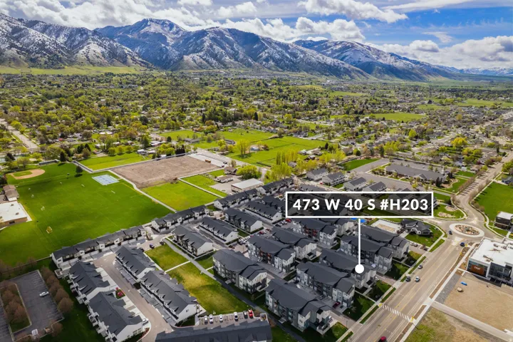 Aerial view of residential area with a mountain backdrop and property parcel outlined