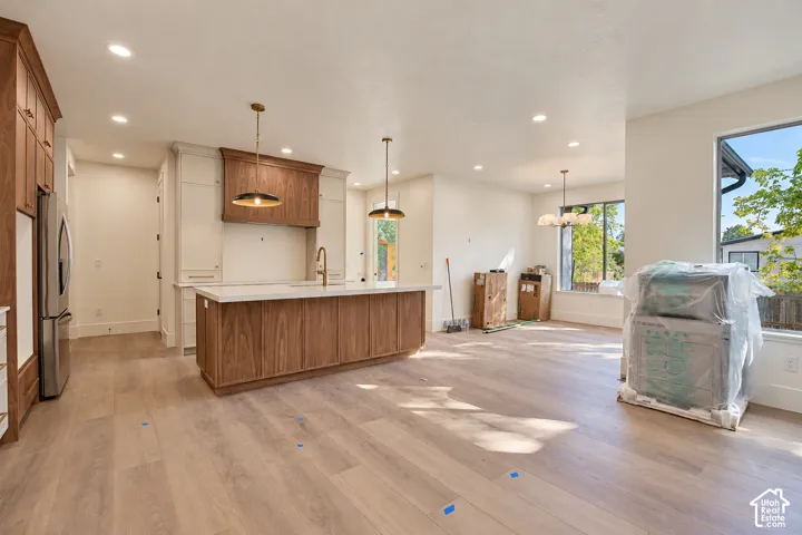 Kitchen with a center island, wood-finish flooring, recessed lighting, and large windows