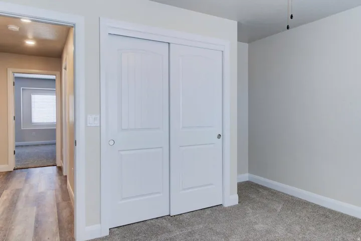 Unfurnished bedroom featuring a closet and light colored carpet