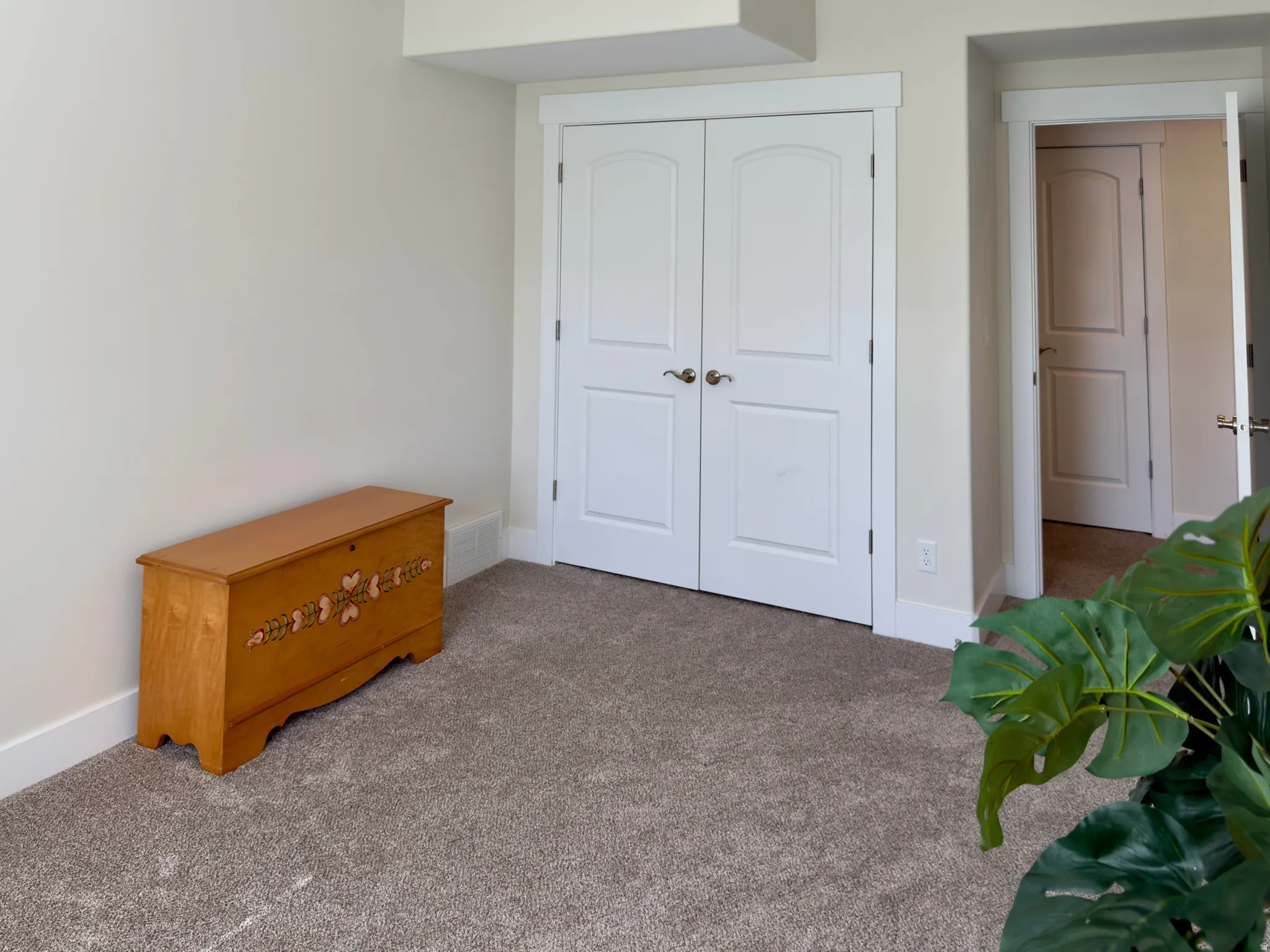Carpeted bedroom with a closet and baseboards