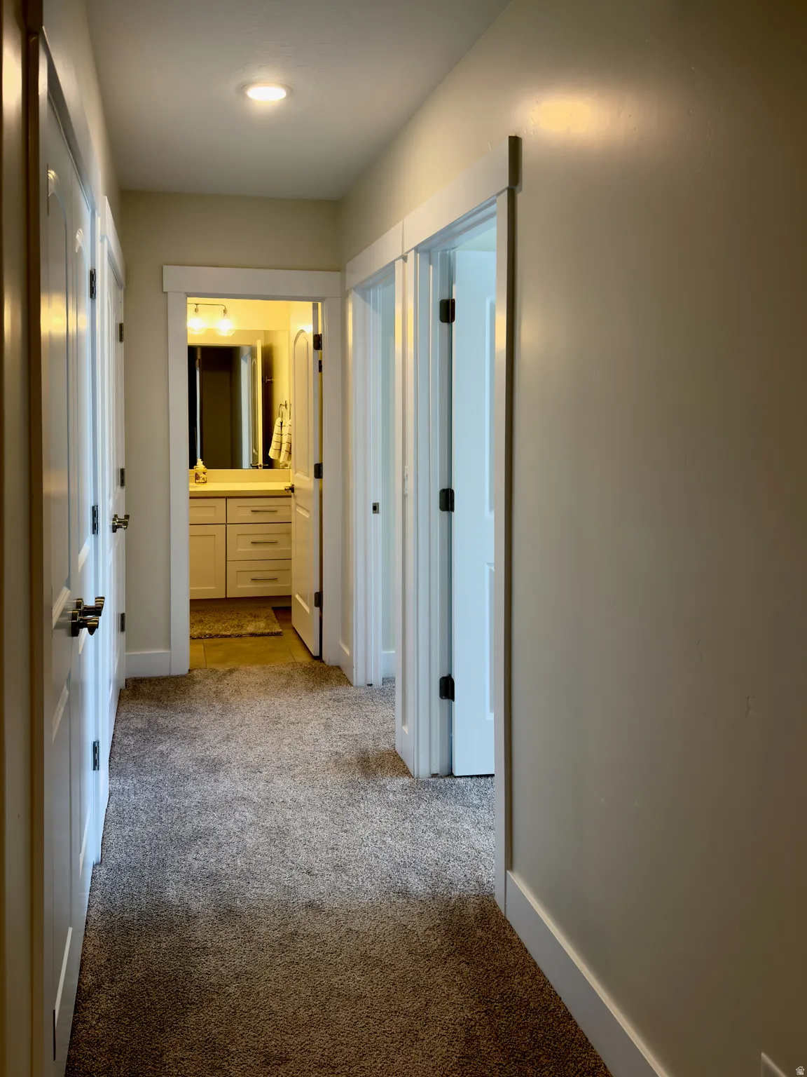 Corridor featuring light carpet and baseboards