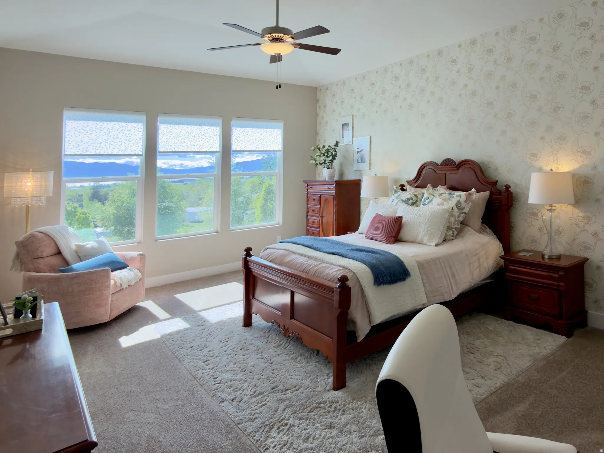 Carpeted bedroom with wallpapered walls and a ceiling fan