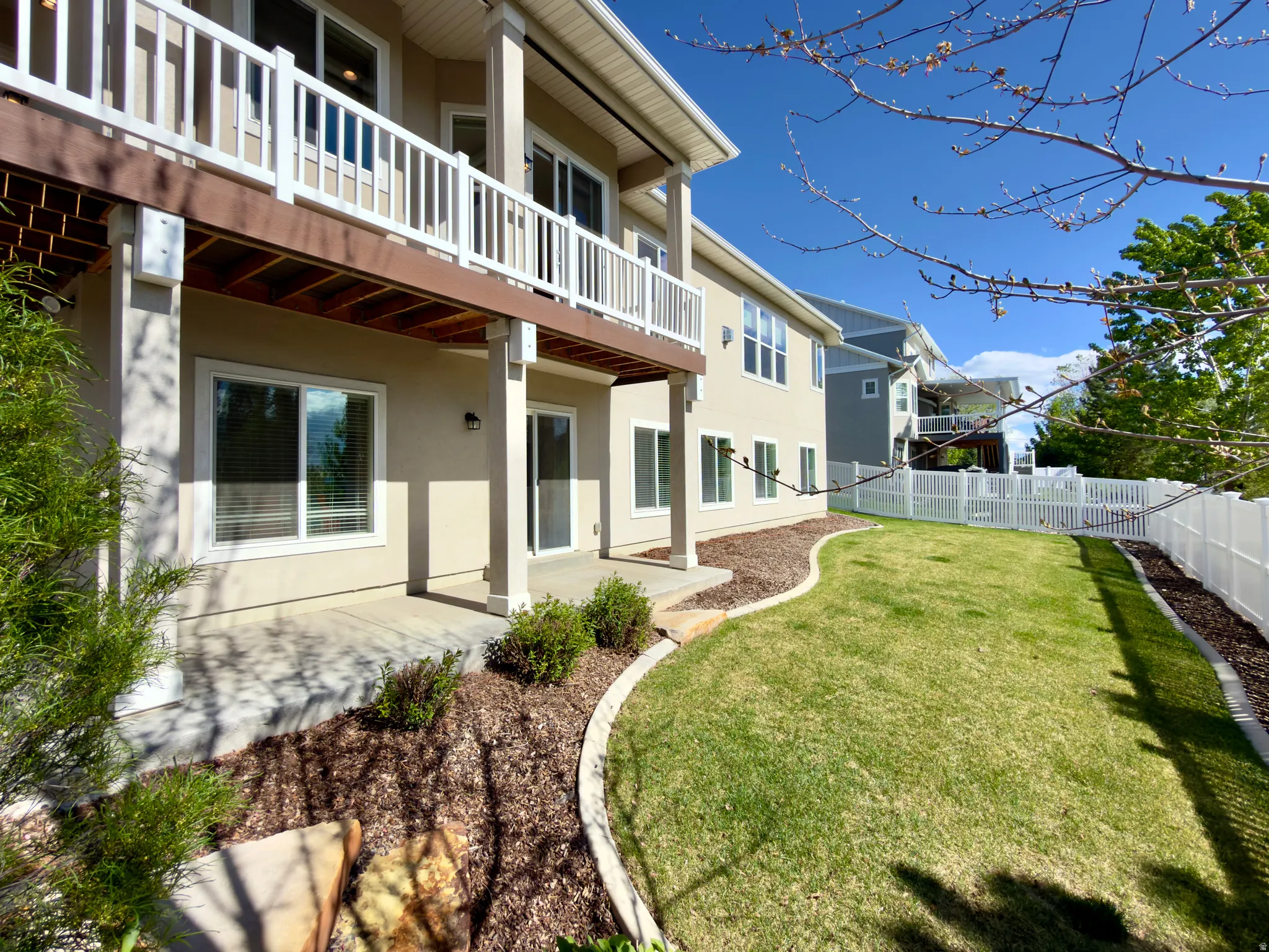 Fenced backyard featuring a patio and a balcony