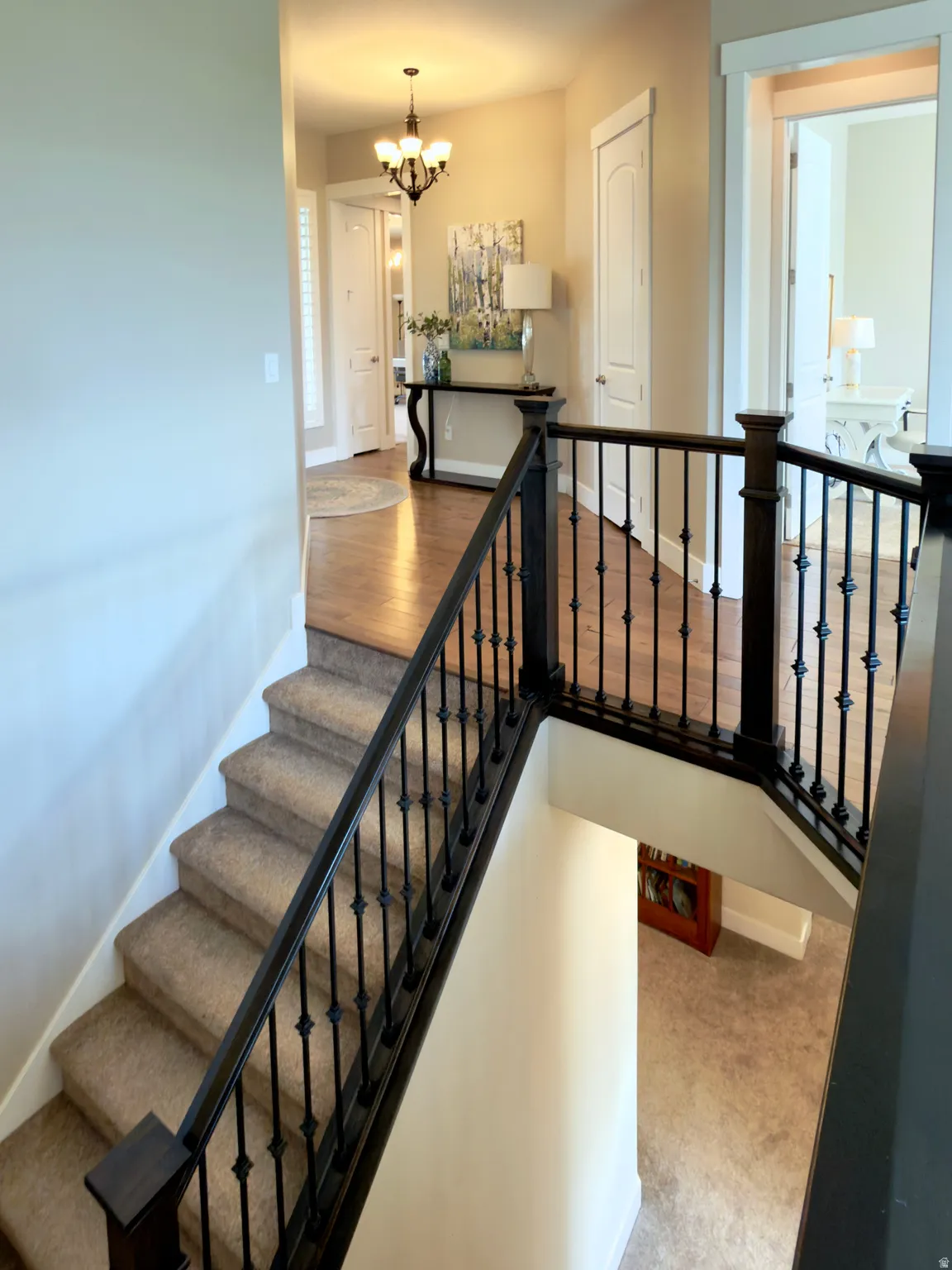 Stairway featuring hanging lights and carpet floors