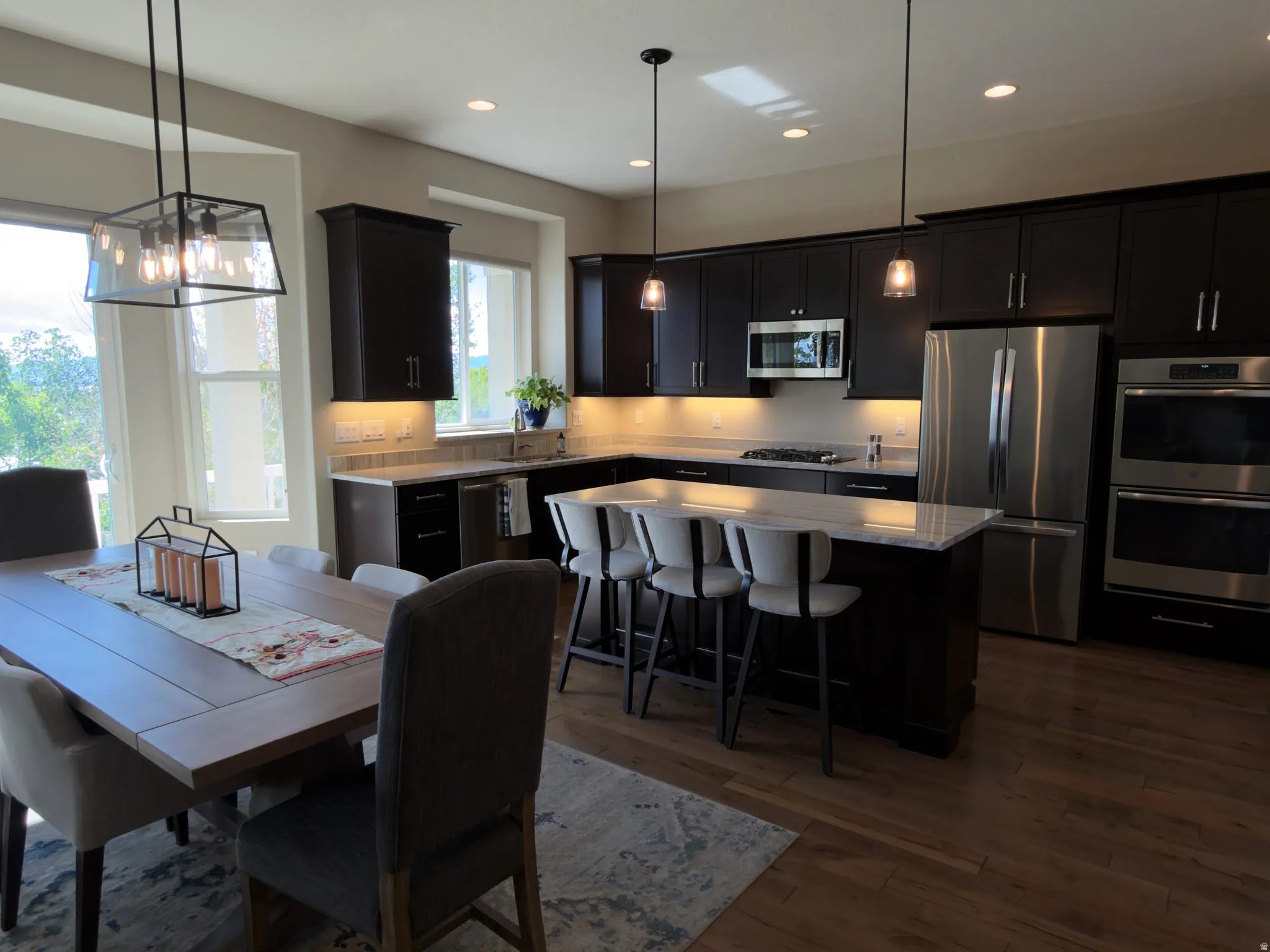 Dining area with dark wood finished floors and hanging lights