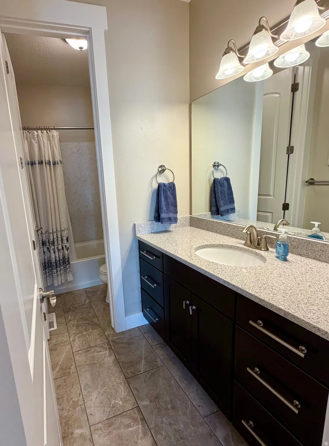 Bathroom featuring vanity and shower / bath combo
