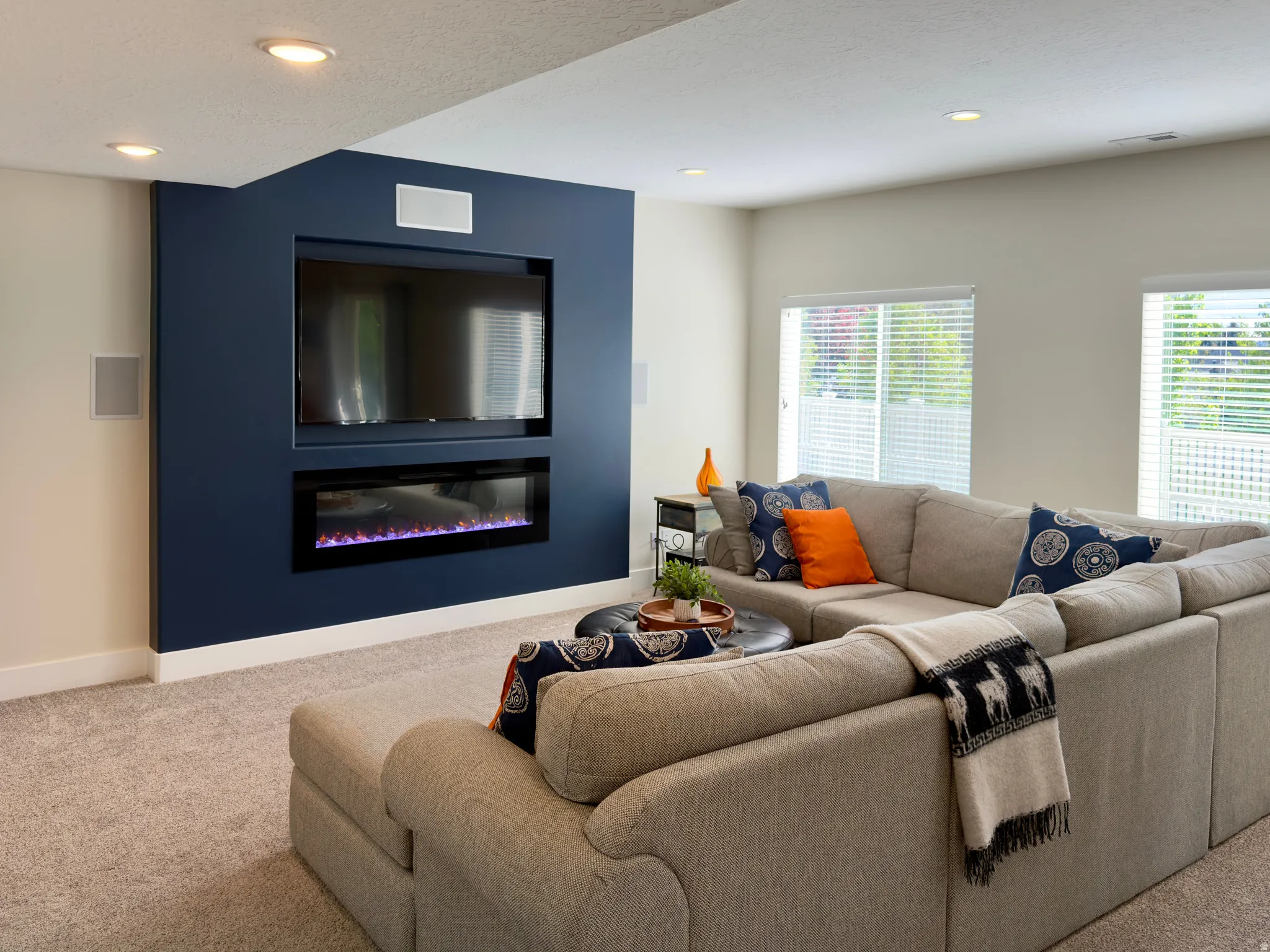 Living area featuring carpet, a glass covered fireplace, and recessed lighting