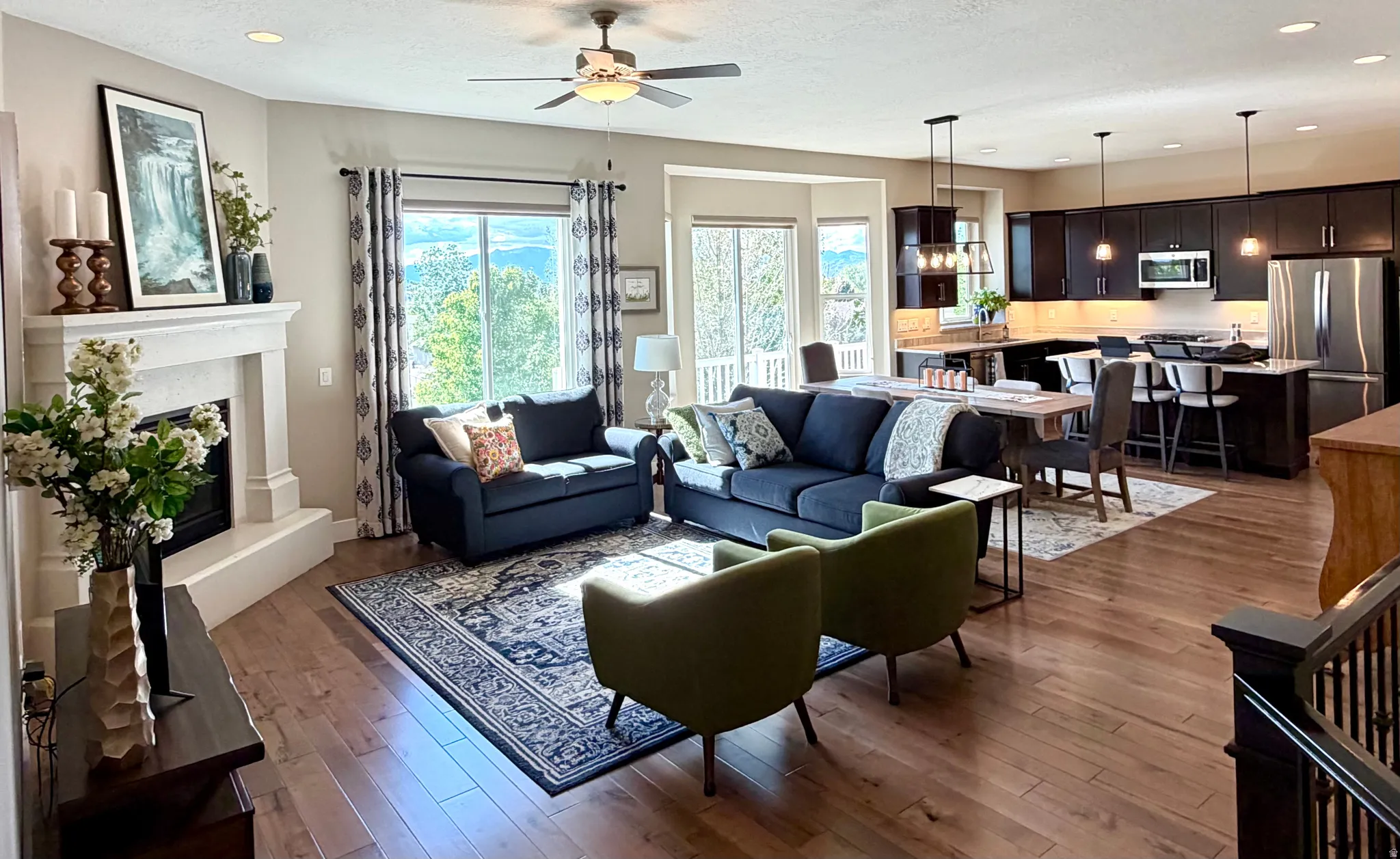 Living room featuring recessed lighting, dark wood-style floors, ceiling fan, and a glass covered fireplace